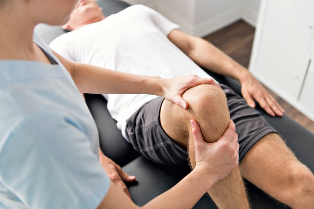 A Patient at the physiotherapy doing physical exercises with his therapist