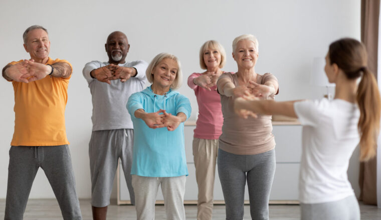 Sporty elderly people having fitness class, training with instructor