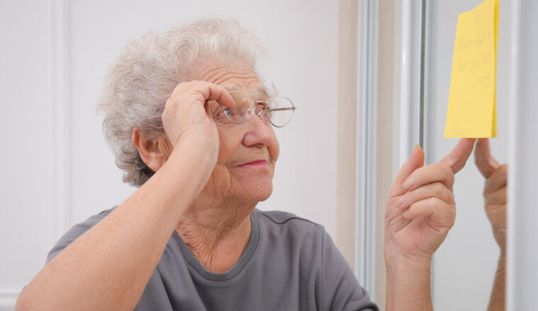 Elderly Woman staring at a yellow note